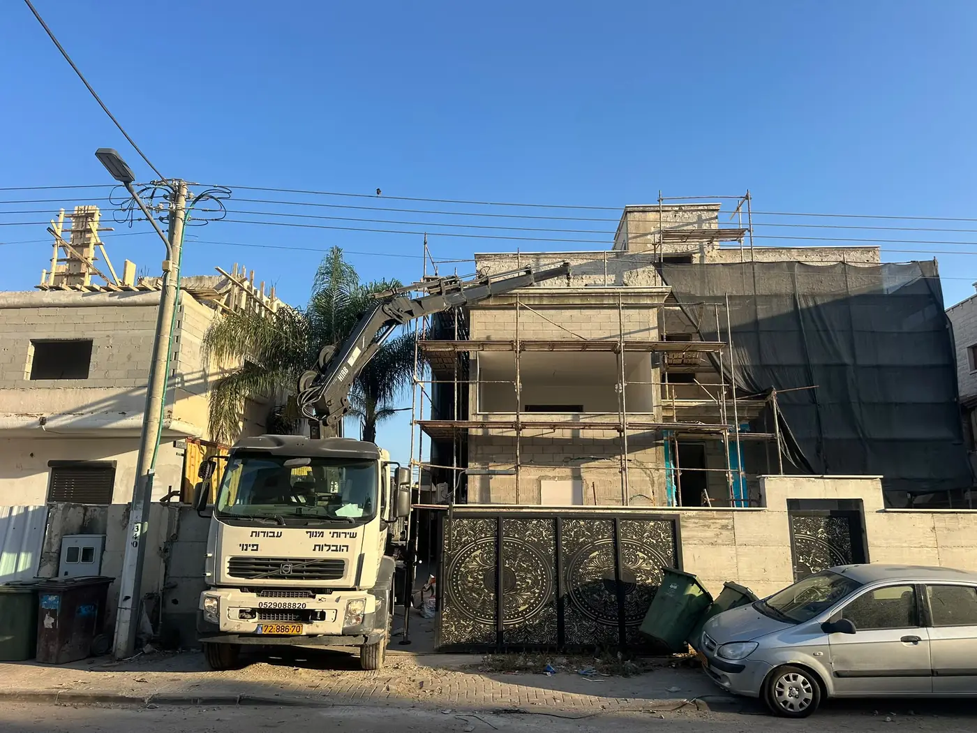 משאית מנוף של ק.נ. פינוי בעבודה באתר בנייה